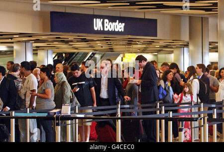 Code al controllo di frontiera nel terminal 5 dell'aeroporto di Heathrow di Londra, dove alcuni membri del personale addetto all'immigrazione e alla dogana si sono Uniti a una giornata di scioperi di insegnanti, funzionari pubblici e altri lavoratori contro i piani del governo per cambiare le pensioni, tagliare posti di lavoro e congelare la retribuzione. Foto Stock