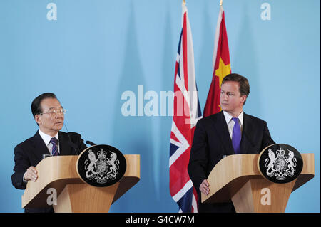 Il primo ministro David Cameron ascolta il discorso del Premier cinese Wen Jiabao durante una conferenza stampa congiunta presso il Ministero degli Esteri di Londra. Foto Stock