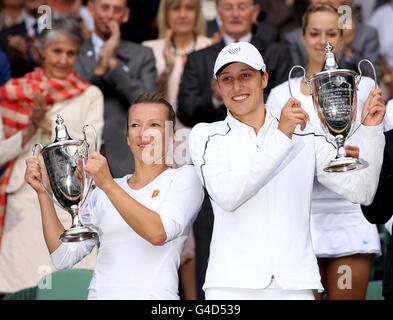 Kveta Peschke della Repubblica Ceca (a sinistra) e Katarina Srebotnik della Slovenia (a destra) festeggiano con i loro trofei dopo aver sconfitto la tedesca Sabine Lisicki e la austriaca Samantha Stosur nella finale doppia per Signore il dodicesimo giorno dei Campionati di Wimbledon 2011 all'All England Lawn Tennis and Croquet Club di Wimbledon. Foto Stock