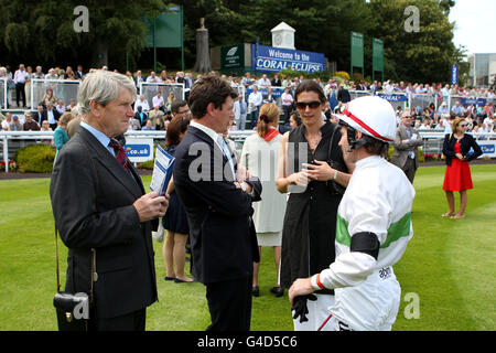 Il formatore Ian Balding (a sinistra) parla con Andrew Balding (al centro) e. Jockey Jimmy Fortune (a destra) prima della carica di Corallo Foto Stock