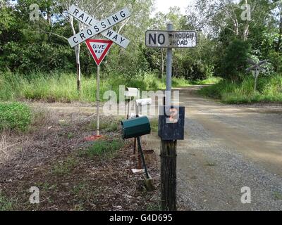 Country Road attraversando una canna da zucchero railway Foto Stock