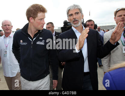 Il principe Harry (a sinistra) parla con Damon Hill mentre camminano lungo il paddock prima del Gran Premio britannico di Formula uno Santander al circuito di Silverstone, Northampton. Foto Stock