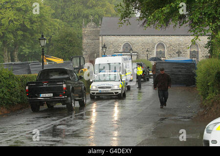 Gli ufficiali forensi e Gardai frequentano la scena nel cimitero di Urbleshanny a Scotstown, Co.Monaghan, dove hanno effettuato un'esumazione dopo un rovesciamento che la tomba può essere stata usata per seppellire una vittima adolescente IRA più di 35 anni fa. Foto Stock