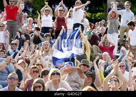 Tennis - 2011 Wimbledon Championships - Day Eleven - The All England Lawn Tennis and Croquet Club. I fan di Andy Murray su Murray Mount celebrano un punto mentre guardano la semifinale sullo schermo gigante Foto Stock