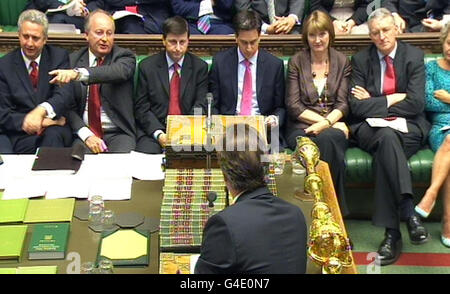 Il primo ministro David Cameron si squarcia contro i laburisti di fronte benchers (sinistra - destra) Ivan Lewis, Shaun Woodward, Douglas Alexander, ed Miliband, Harriet Harman e Hilary Benn mentre risponde durante le domande del primo ministro nella Camera dei Comuni, Londra. Foto Stock