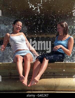 Vicky Woodcock (a sinistra) e Nicola Wilden dall'Essex si tuffano nelle fontane di Trafalgar Square, a Londra, in uno dei giorni più caldi dell'anno, quando le temperature hanno raggiunto i 25°C nella capitale. Foto di Stefan Rousseau./PA Foto Stock