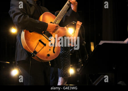 Fotografia di un musicista di suonare la chitarra e una donna cantare Foto Stock