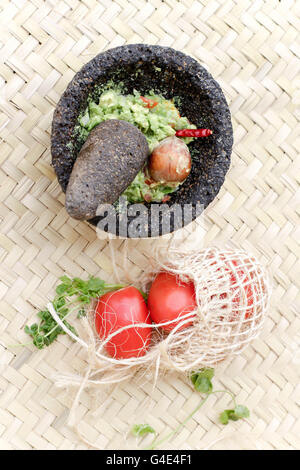 Fotografia di fracassato advocado, guacamole in un tradizionale di pietra molcajete Foto Stock