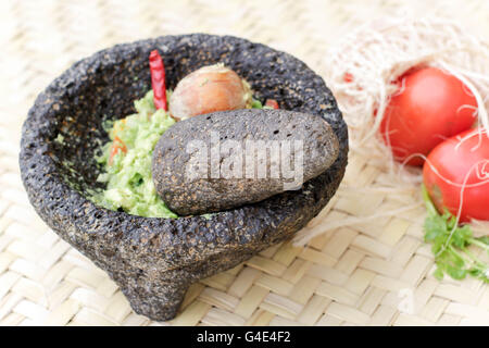 Fotografia di fracassato advocado, guacamole in un tradizionale di pietra molcajete Foto Stock