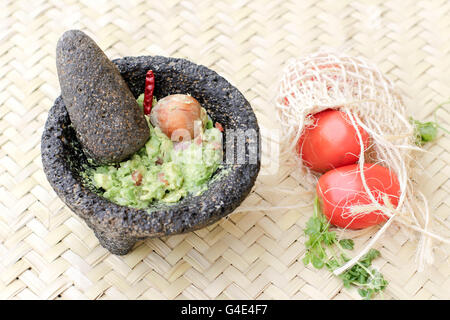 Fotografia di fracassato advocado, guacamole in un tradizionale di pietra molcajete Foto Stock