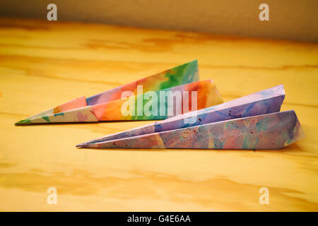 Fotografia di alcuni tipi di carta colorati aeroplani su una tavola di legno Foto Stock