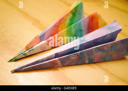 Fotografia di alcuni tipi di carta colorati aeroplani su una tavola di legno Foto Stock