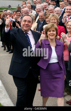 Il leader della SNP Alex Salmond e il vice leader della SNP Nicola Sturgeon con i nuovi membri della SNP al di fuori del Parlamento scozzese a Edimburgo, dopo la vittoria senza precedenti della SNP alle elezioni del Parlamento scozzese. Foto Stock