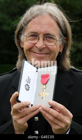 Il cantante scozzese Dougie Maclean tiene la sua OBE che ha ricevuto oggi dalla Regina in una cerimonia di investitura al Palazzo di Holyroodhouse a Edimburgo. Foto Stock