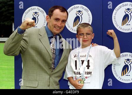 Ryan Whitelock (6) di Chelmsford e un Kidney Transplantee & membro del team di Great Ormond Street Renal, vincitore dei 50 metri per i ragazzi di 5-7 anni riceve le sue medaglie da Barry McGuigan ai Guardian Health British Transplant Games di Belfast al Mary Peters Track Today (domenica) Foto Stock