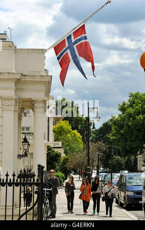 La bandiera nazionale della Norvegia vola a metà palo dalla reale ambasciata norvegese, nel centro di Belgravia a Londra, per rispetto delle 84 persone uccise in due attacchi in Norvegia venerdì. Foto Stock