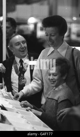 PA NEWS PHOTO 11/1/87 LA PRINCIPESSA ANNE CONDIVIDE UNA BATTUTA CON GEORGE HULLEY, PRESIDENTE DELLA BRITISH MARINE INDUSTRIES FEDERATION, MENTRE SUO FIGLIO MASTER PETER PHILLIPS ESAMINA I SOUVENIERS ALLA 33A FIERA INTERNAZIONALE BAOT ALLA CORTE DEGLI EARLS DI LONDRA. Foto Stock