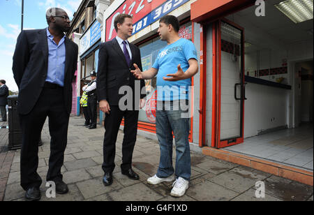 Il vice primo ministro Nick Clegg e il deputato di Tottenham David Lammy incontrano i residenti locali e gli uomini d'affari, tra cui il proprietario del negozio di pizza Mohammed Nabi Ayubi, dopo lo scoppio dei saccheggi a Tottenham, a nord di Londra, sabato sera. Foto Stock