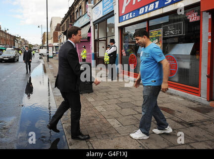 Il vice primo ministro Nick Clegg incontra i residenti locali e gli uomini d'affari, tra cui il proprietario del negozio di pizza Mohammed Nabi Ayubi, dopo lo scoppio di un radicamento a Tottenham, nel nord di Londra il sabato sera. Foto Stock