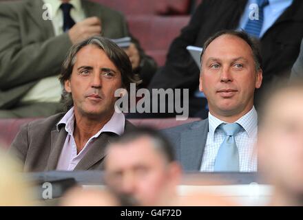 Calcio - Barclays Premier League - Manchester United v Tottenham Hotspur - Old Trafford. Il manager della città di Manchester Roberto Mancini (a sinistra) e il primo allenatore del team David Platt (a destra) negli stand Foto Stock