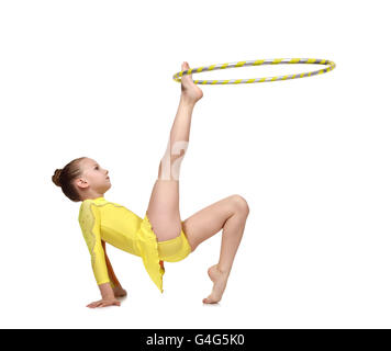 Atleta artistico esegue in abiti di colore giallo con hula hoop Foto Stock