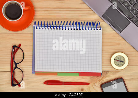 Notebook bianco e il materiale office desktop sulla scrivania in legno, vista dall'alto. Foto Stock