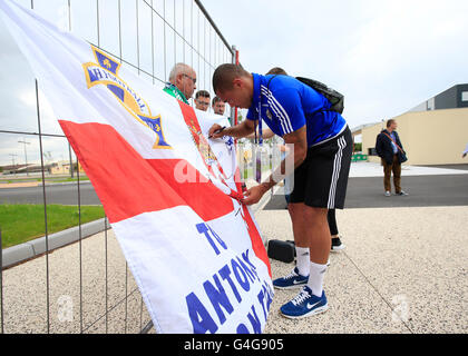 In Irlanda del Nord la Josh Magennis segni un fans bandiera prima di partecipare a una conferenza stampa di Saint-George-de-Reneins. Foto Stock