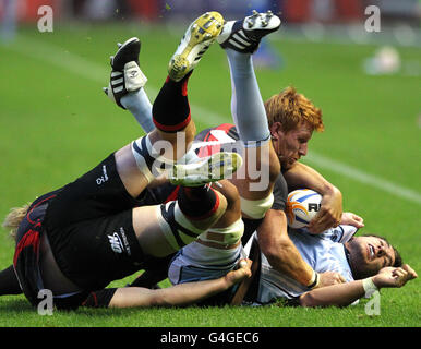 Roddy Grant (centro) di Edimburgo fa un tacking durante la partita di RaboDirect PRO 12 a Murrayfield, Edimburgo. Foto Stock