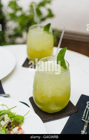 Verde Tropical cocktail limonata con limone, menta fresca e gelato al caffè all'aperto durante il pranzo in estate Foto Stock