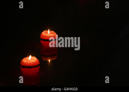 Due round di illuminazione candele nel buio. Foto Stock