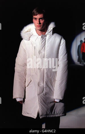 Un modello sulla passerella presenta un cappotto bianco disegnato da John Richmond, durante la sua sfilata di moda presso i Royal Horticultural Halls di Londra per la settimana della Moda maschile Foto Stock