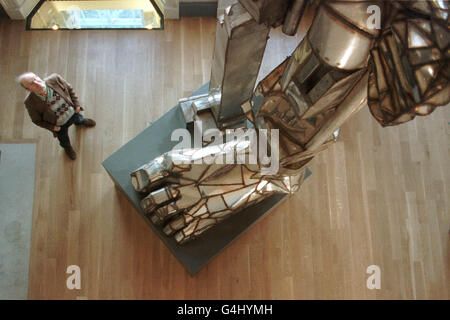 L'uomo guarda fino alla scultura Paolozzi Foto Stock