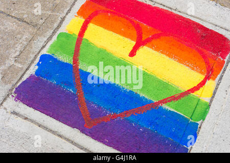 Gay-bandiera arcobaleno e cuore rosso dipinto su un marciapiede Foto Stock