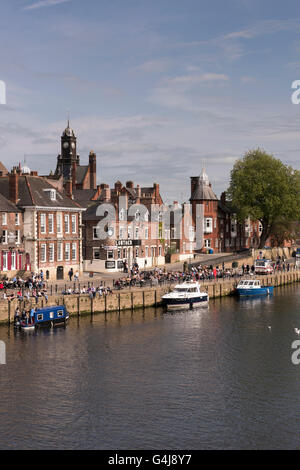 Molte persone bevono e si rilassano al sole nei pub affollati lungo il fiume e nelle barche per il tempo libero ormeggiate sul fiume Ouse - King's Staith, York, North Yorkshire, Inghilterra. Foto Stock