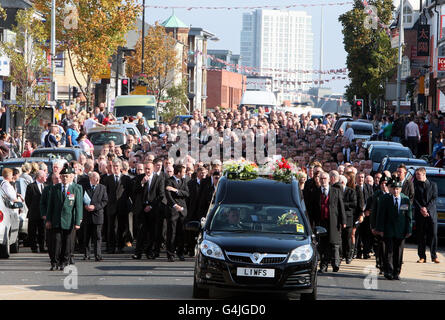 La bara, coperta con la bandiera dell'Ulster Rifles e il suo beretto, dell'ex leader UVF Gusty Spence passa lungo la Shankill Road a Belfast dopo il suo funerale alla Chiesa di San Michele. Foto Stock