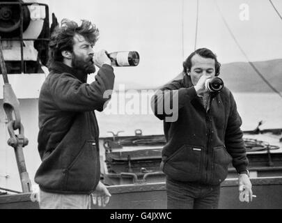 Sir Ranulph Fiennes (l) e Charles Burton (r) ricevono una bevanda festiva mentre si mettevano piede su terreno solido a Longyearbyen, Spitzbergen, Norvegia, per l'inizio della fine del loro giro epico la spedizione mondiale in cui hanno toccato entrambi i polacchi. Arrivarono dopo che la nave britannica Tranglobo Expedition, MV Benjamin Bowring, era stata intrappolata nella calotta polare per 12 giorni. Gli esploratori sperano di tornare a Greenwich, Londra, alla fine del mese (agosto) per essere accolti dal loro patrono, il Principe di Galles. Foto Stock