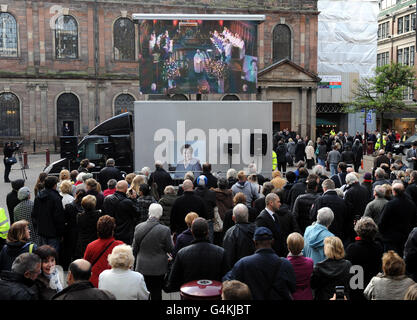 I fan di Coronation Street si riuniscono per pagare i loro rispetti mentre osservano il servizio funerale dell'attrice Betty driver su uno schermo fuori dalla chiesa di St Ann nel centro di Manchester. Foto Stock