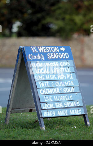 Un cartello per un negozio di pesce locale nel piccolo villaggio portuale di pescatori di Blakeney sulla costa nord del Norfolk. Foto Stock