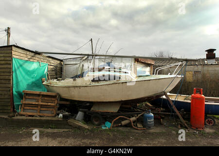 Una barca spicca fuori dall'acqua sulla banchina A Wells-next-the-Sea sulla costa nord del Norfolk Foto Stock