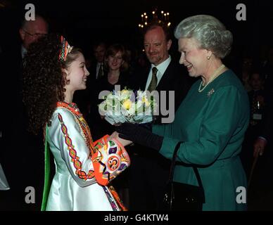 La regina britannica Elisabetta II, guardata dal segretario del Forign Robin Cook e da sua moglie Gaynor, riceve un mazzo di fiori da una ragazza in costume tradizionale ad un ricevimento per il 50° anniversario del Consiglio d'Europa, tenuto a St. James's Palace a Londra. Foto Stock