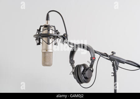 Microfono a condensatore di qualità professionale con le cuffie su un cavalletto. Sfondo bianco. Foto Stock