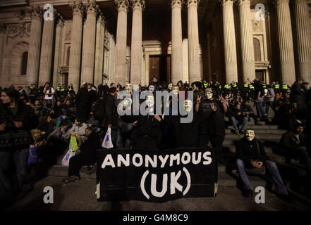 Manifestanti che portano un banner britannico anonimo fuori dalla cattedrale di St Paul a Londra mentre la gente protesta contro il sistema finanziario globale. Foto Stock