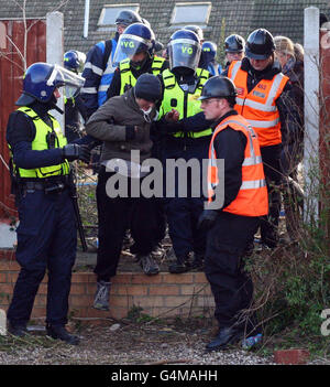 Un protestante è guidato via da un poliziotto presso la fattoria di Dale vicino a Basildon, Essex, il secondo giorno del previsto sfratto del sito dei viaggiatori. Foto Stock