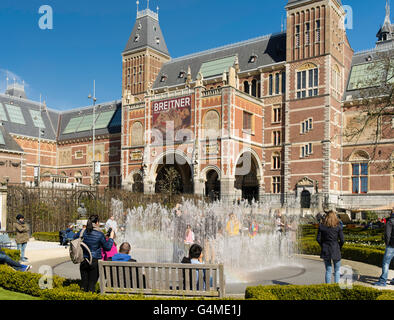 Le persone si raccolgono al di fuori di Amsterdam il Rijksmuseum per giocare in un giardino fontana in una bella giornata di primavera. Foto Stock