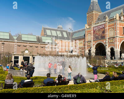 Le persone si raccolgono al di fuori di Amsterdam il Rijksmuseum per giocare in un giardino fontana in una bella giornata di primavera. Foto Stock
