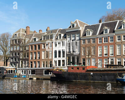 Una vista lungo uno di Amsterdam i tanti canali in una bella giornata di primavera. Foto Stock