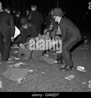 Un dimostratore è sollevato da agenti di polizia sulla strada a Grosvenor Square, Londra, vicino all'ambasciata degli Stati Uniti. I dimostranti, stimati al 2,000, protestavano contro il blocco americano di Cuba. Foto Stock