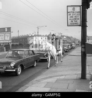 Il trasporto personale ha girato un cerchio completo per il sig. Harry Maltby, un ufficiale del circo a Belle Vue, Manchester. Per battere il traffico e il mal di testa del parcheggio, ha abbandonato la sua auto e ha adottato il metodo dell'età pre-motore, ha portato a utilizzare un cavallo per il suo giro giornaliero di visite della città. Qui si vede andare comodamente su Smoky, un cacciatore, mentre i piloti si fumano alla lunga attesa in una coda di auto Foto Stock