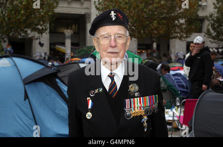 Il veterano del D-Day Wally Harris MM, 91 anni, che combatté sulla Gold Beach in Normandia il D-Day e faceva parte della forza che liberò Brussells per la quale vinse la Medaglia militare per il gallantry, fuori dalla cattedrale di St Paul a Londra. È venuto a dire ai manifestanti di spostare le tende per la Domenica di memoria in modo che possano tenere il servizio tradizionale. Foto Stock