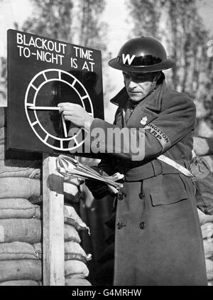 Un warden Air-raid imposta un indicatore di orologio nero su un post A.R.P. vicino a Londra durante la seconda guerra mondiale. Foto Stock